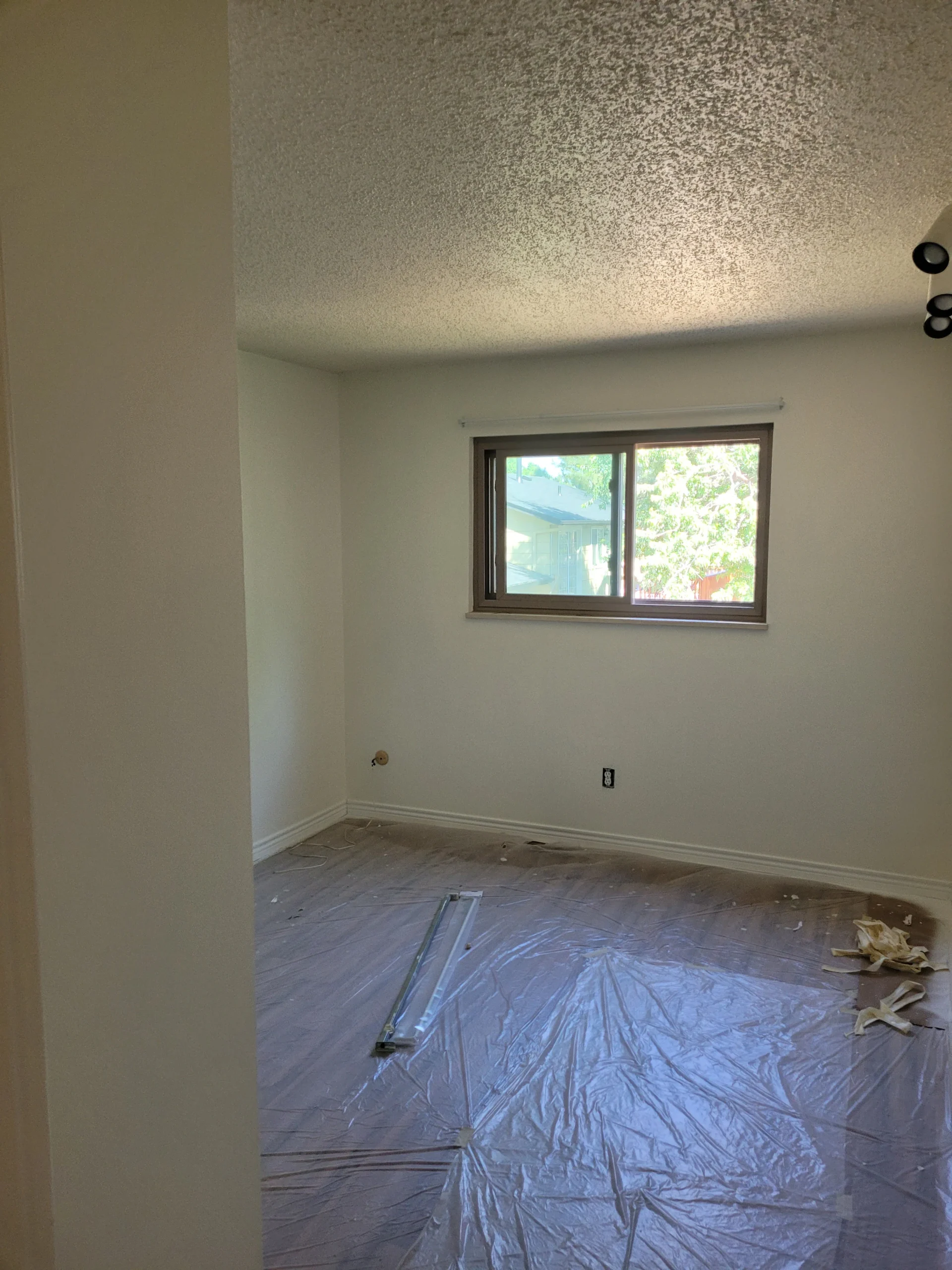 Interior painting preparation in a Colorado Springs home with protected flooring